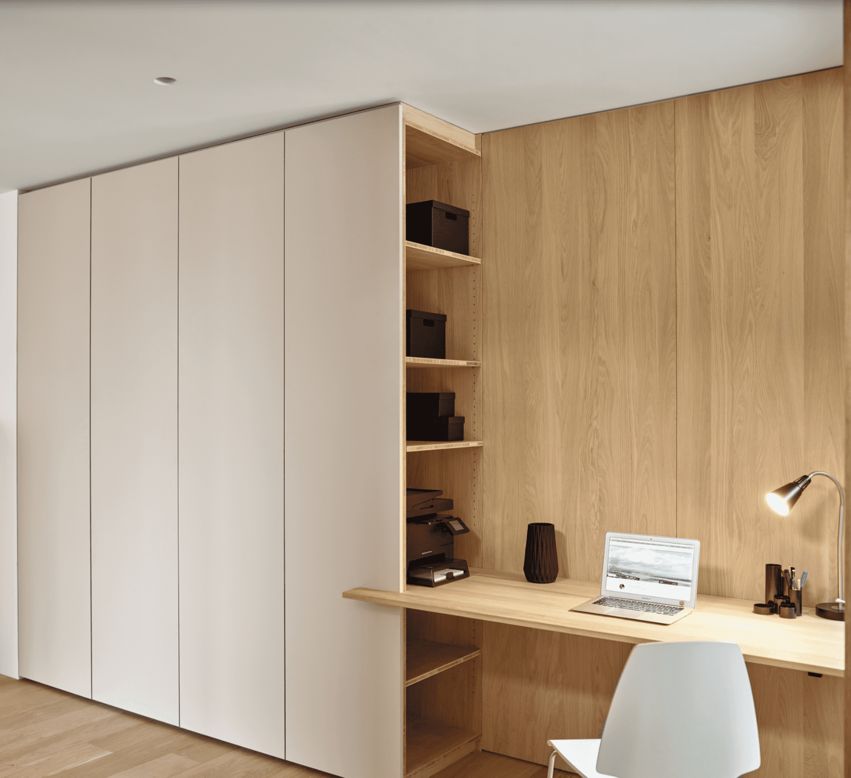 Maßgefertigter Einbauschrank und Schreibtisch in modernem Büro Ein Büro mit maßgefertigtem Einbauschrank in neutralen Farben und integriertem Holzschreibtisch.
