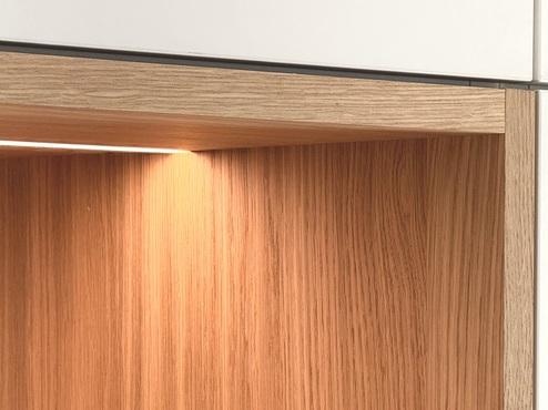 Detailaufnahme eines Holzfachs im Wandschrank mit Beleuchtung