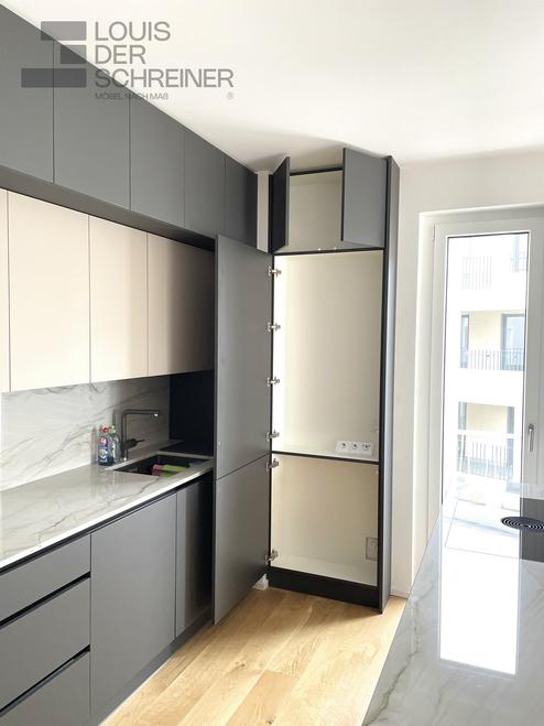 Ein Schrank nach Maß in einer modernen Küche, mattschwarz mit integriertem Hoch- und Oberschrank.
