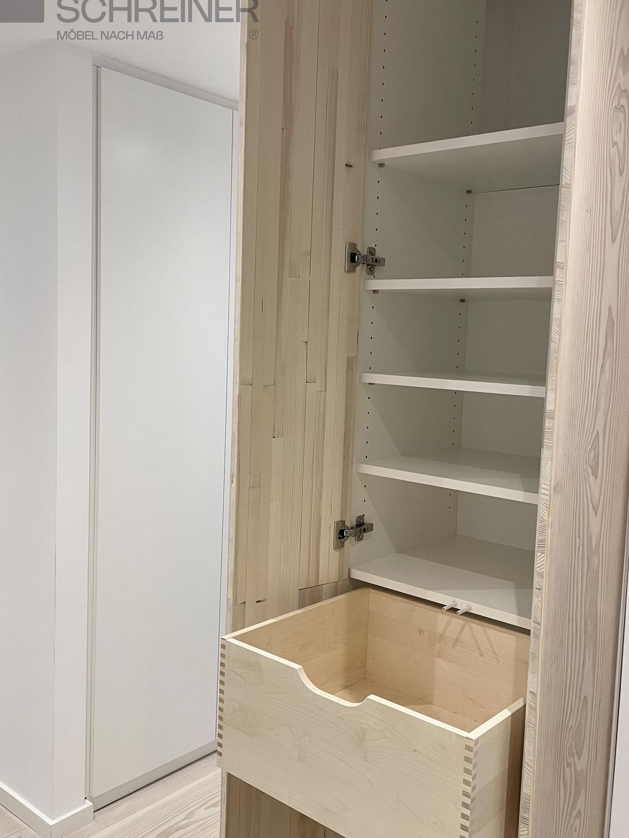 Maßgefertigter Hochschrank mit Holzschublade und verstellbaren Regalböden Ein offener, maßgefertigter Hochschrank mit einer Holzschublade und verstellbaren weißen Regalböden.
