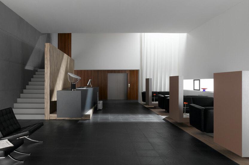 Hotelappartment Untergeschoss mit Holzmobiliar Hotelappartment Untergeschoss mit Holzmobiliar, dunklem Parkett und Treppenaufstieg