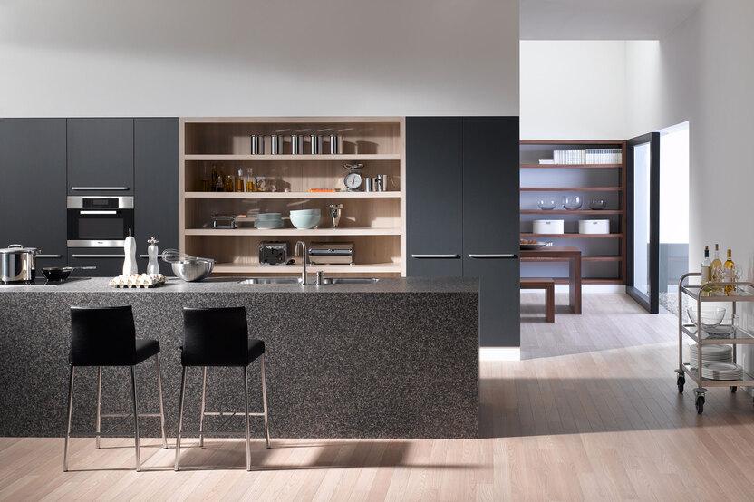 Impression einer offenen K&uuml;che mit K&uuml;chentheke in dunkler Anthrazit-Lackierung