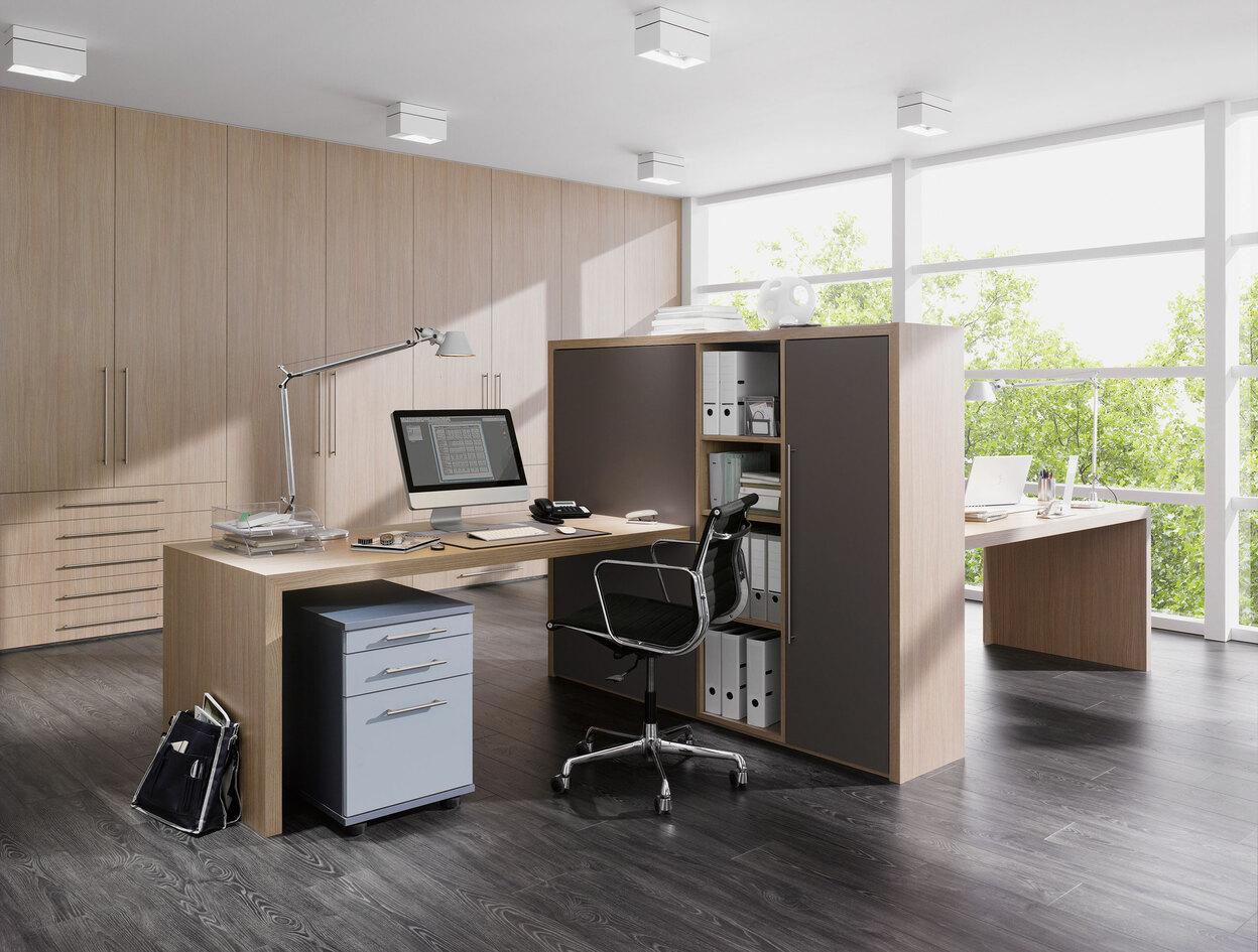 Impression von freistehenden Büromöbeln Impression von freistehenden Büromöbeln in L-Form mit hellem Einbauschrank im Hintergrund
