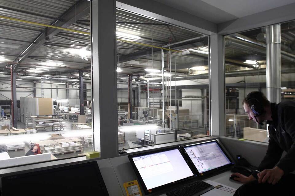 Fertigungshalle mit Überwachungsraum Einblick in Fertigungshalle von abgetrenntem Überwachungsraum via Computer und Fenstern